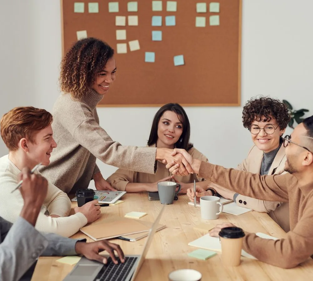 Equipo colaborando alrededor de una mesa de trabajo